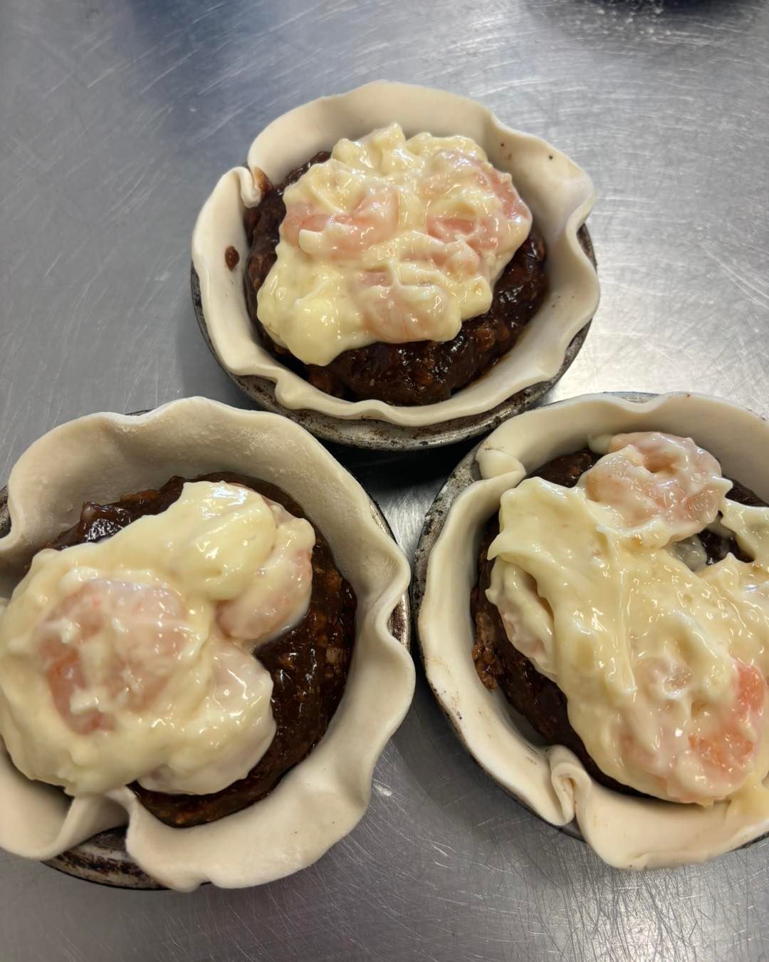 Three Pies Are Sitting on a Table With Sauce on Top — Lismore Pie Cart in Lismore, NSW