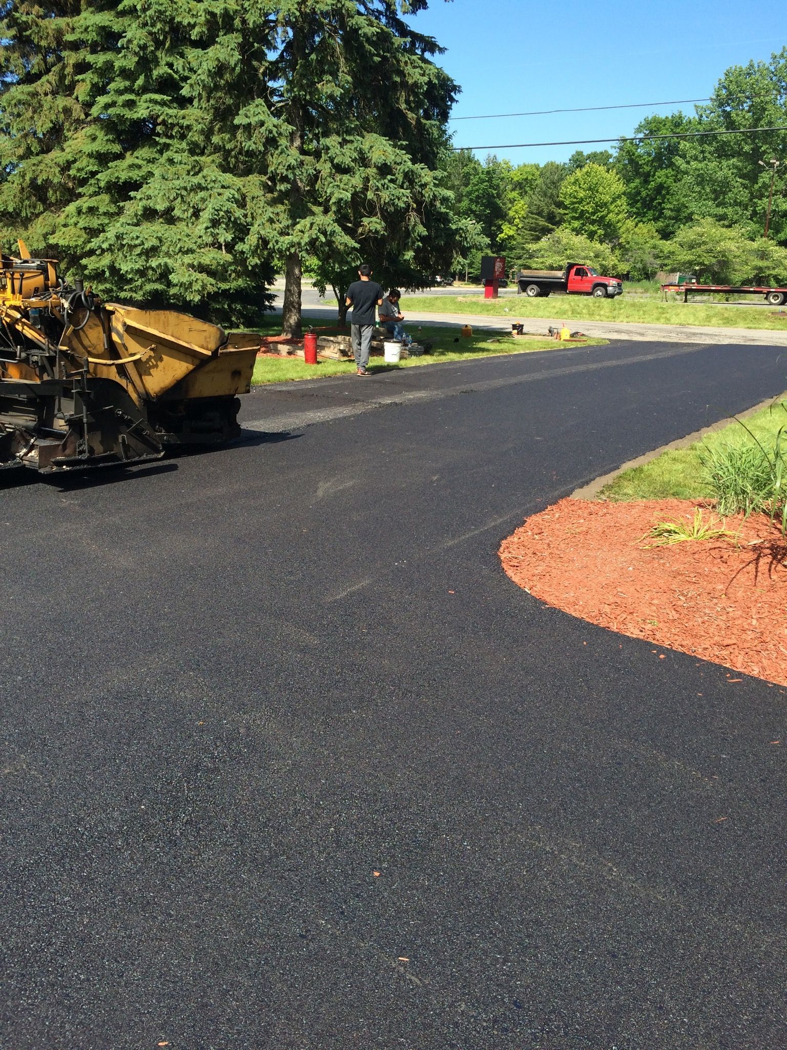 Two people are walking down a path in the woods at sunset.
