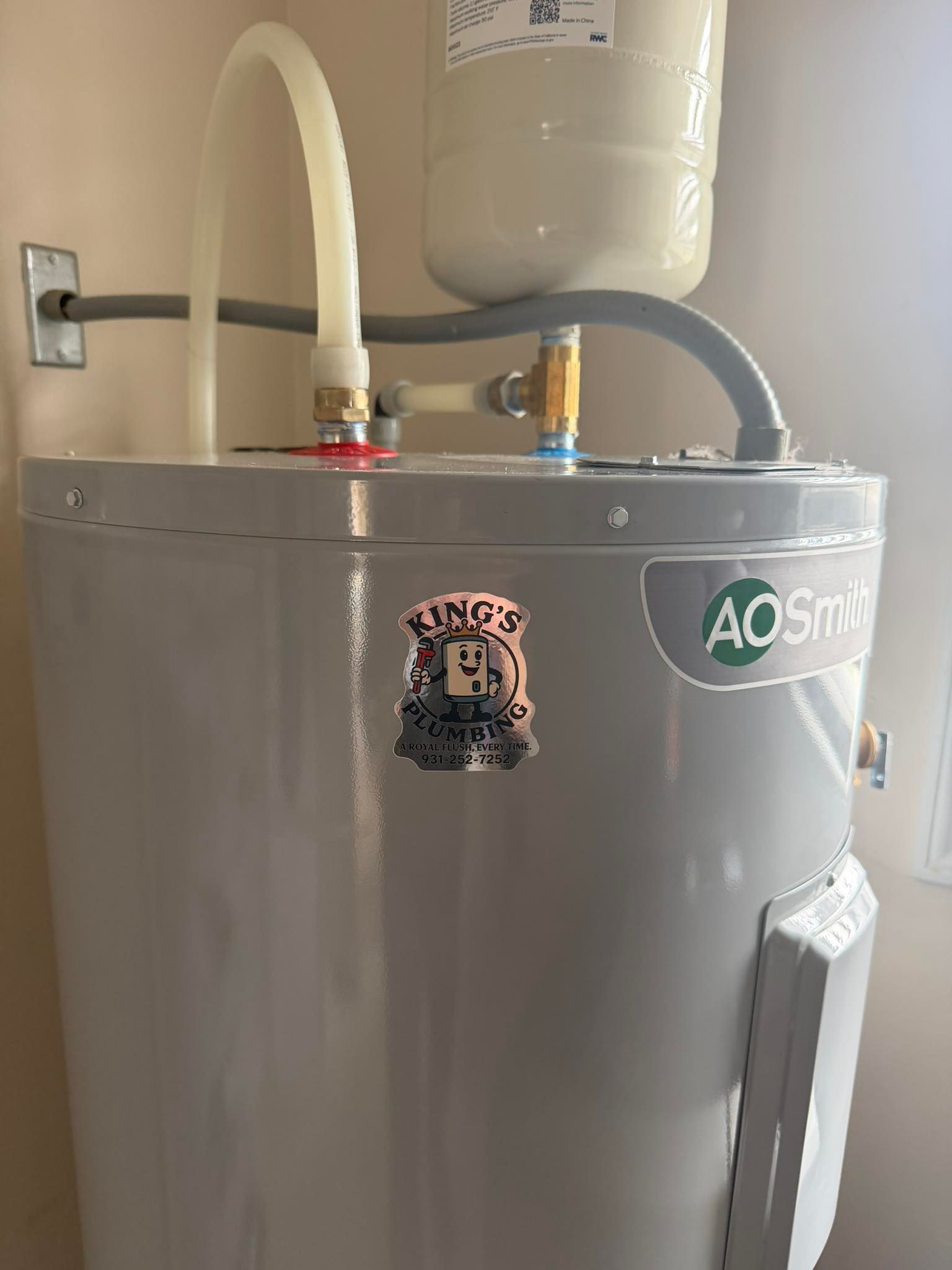 A gray A. O. Smith water heater with a small expansion tank attached to the top piping.