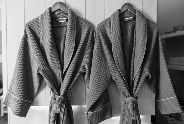 Person receiving shoulder massage at spa. Dark skin, eyes closed, bowl with flower.