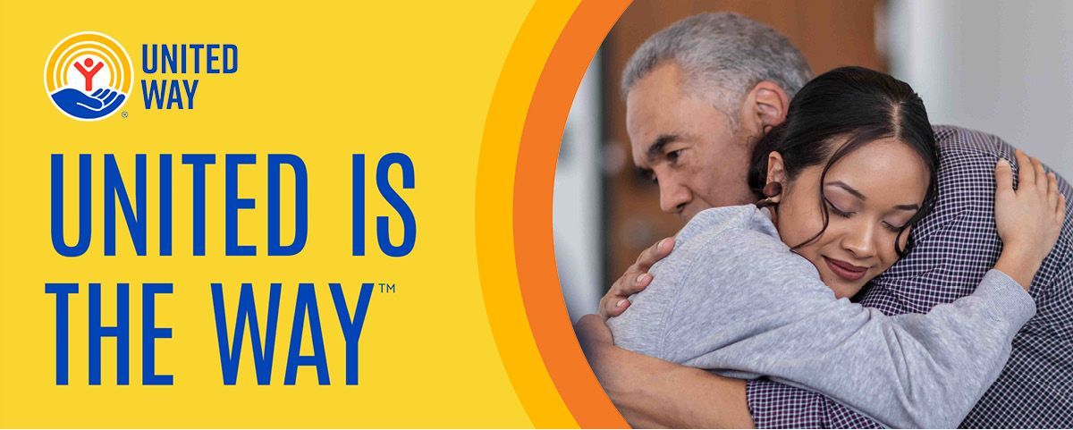 Happy family of four smiles outside; parents giving children piggyback rides.