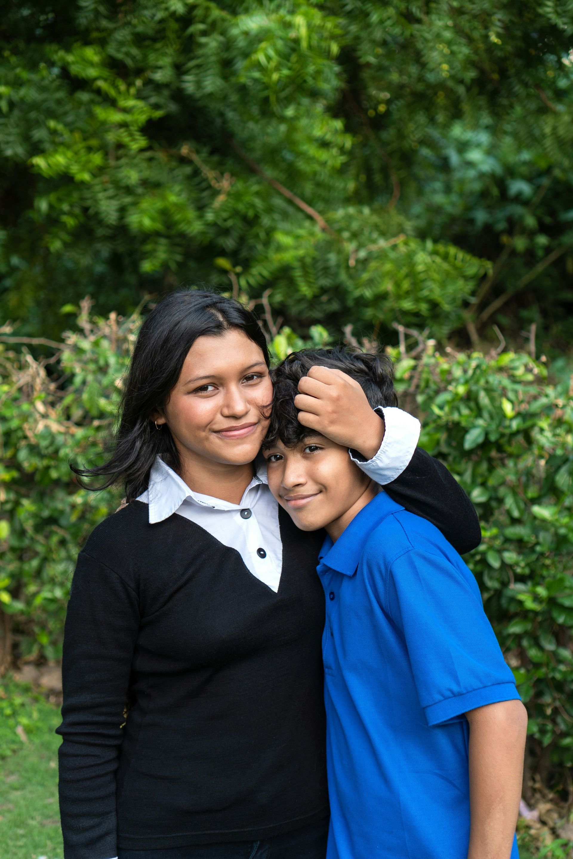 Man and baby lying on green carpet, smiling and looking at each other.