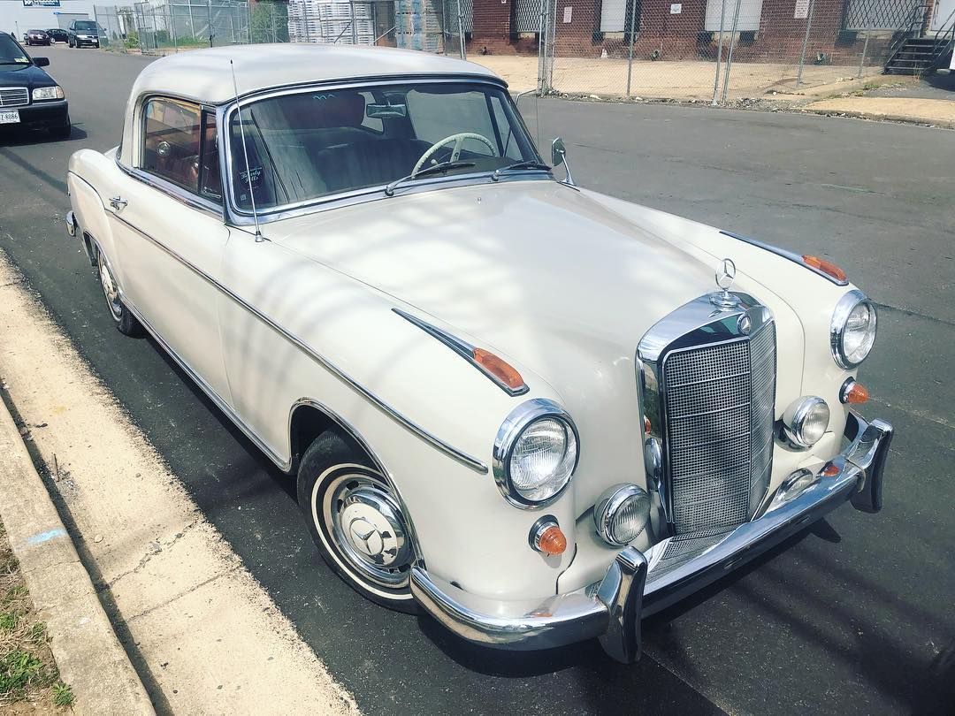 A white car is parked on the side of the road