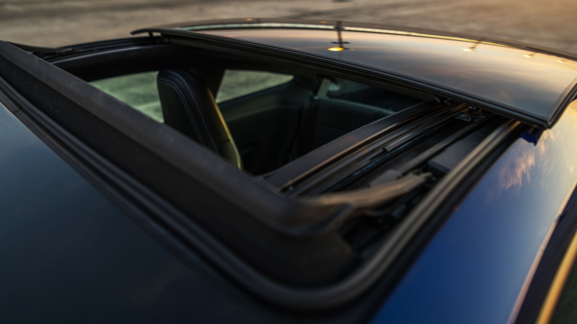 The sunroof of a blue car is open.