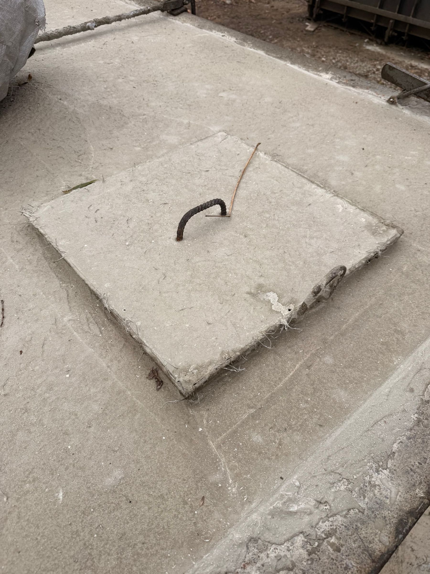 Gravel drainage system under construction near a house and trees, with PVC pipes in the foreground.