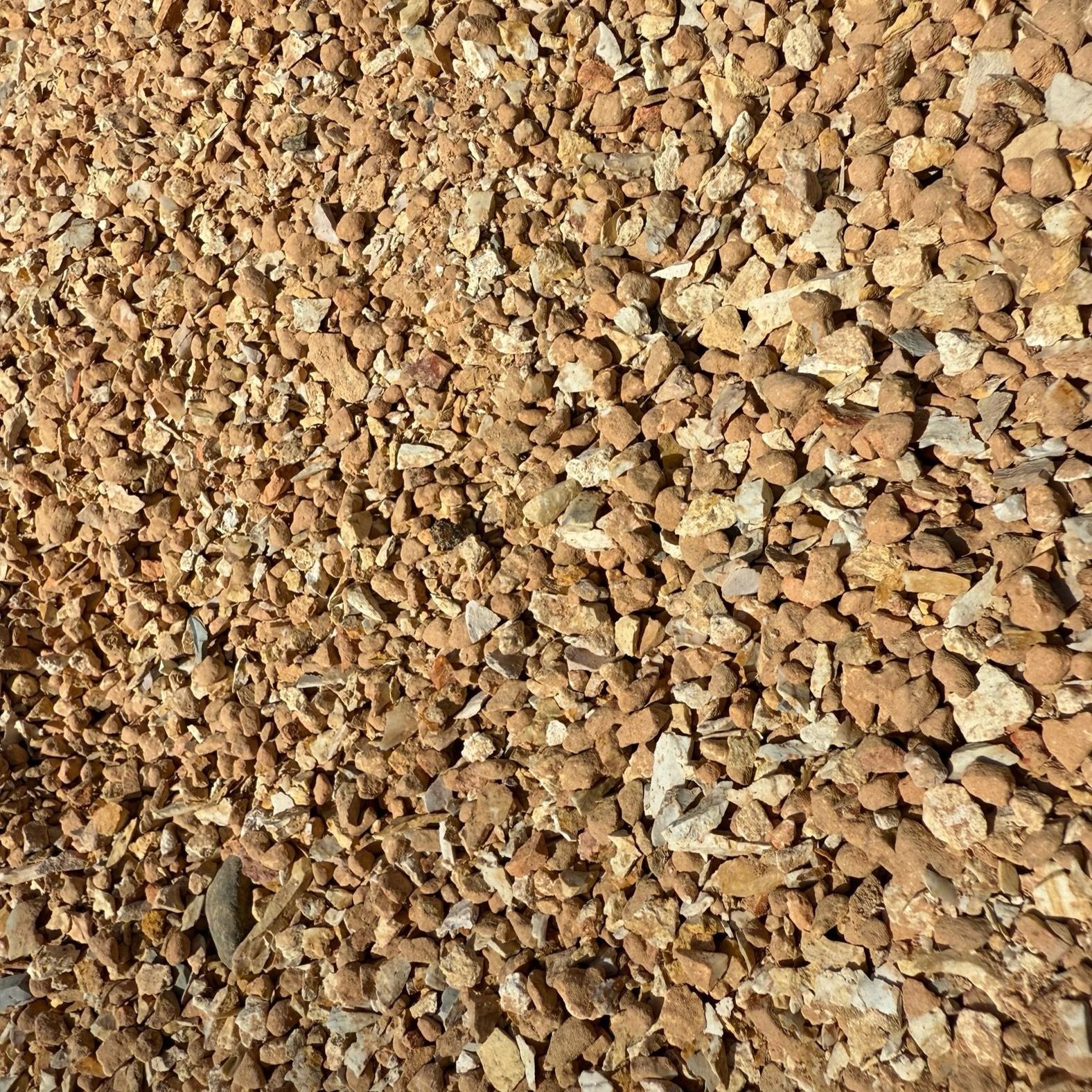 A pile of brown gravel is sitting on the ground.