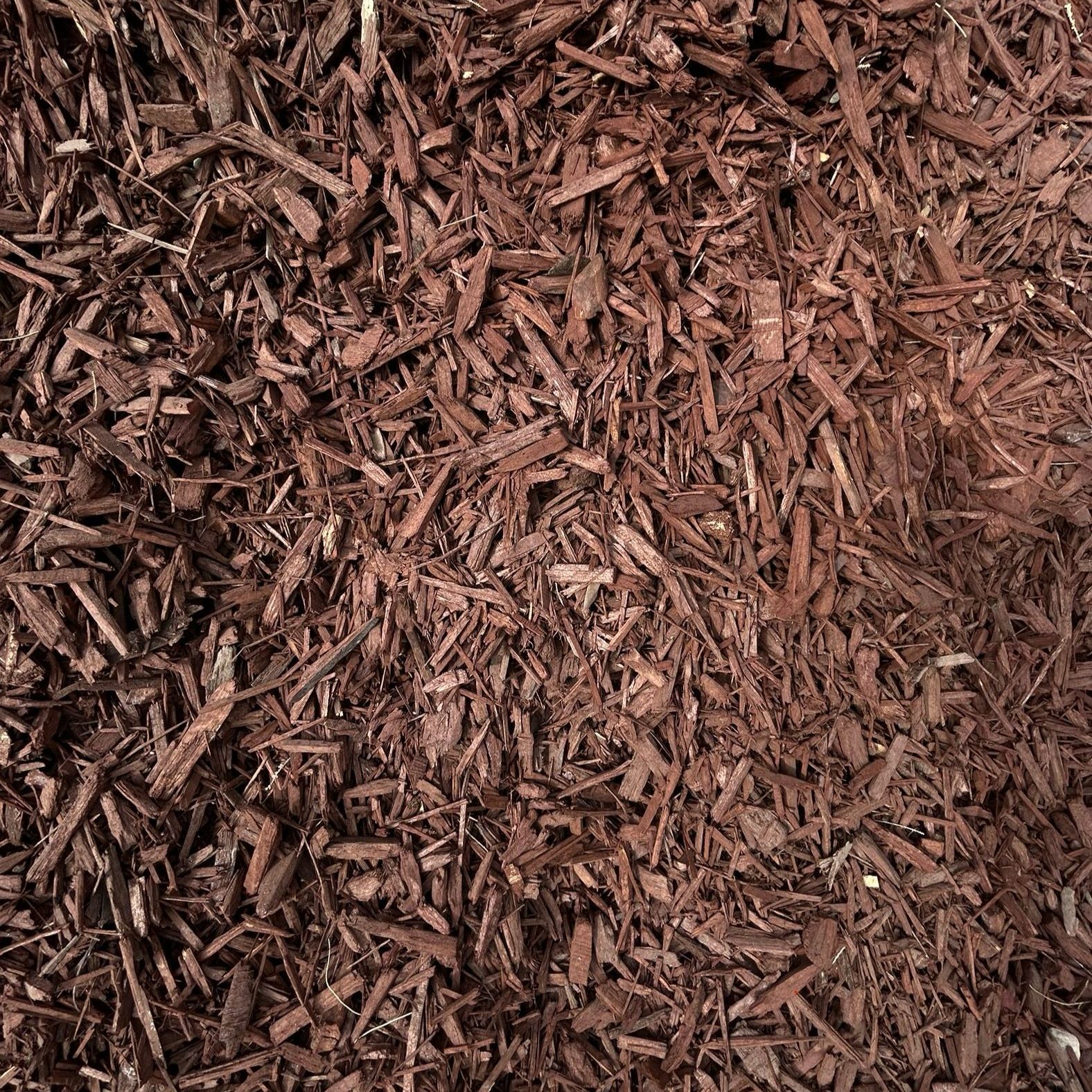 A pile of brown mulch is sitting on the ground.