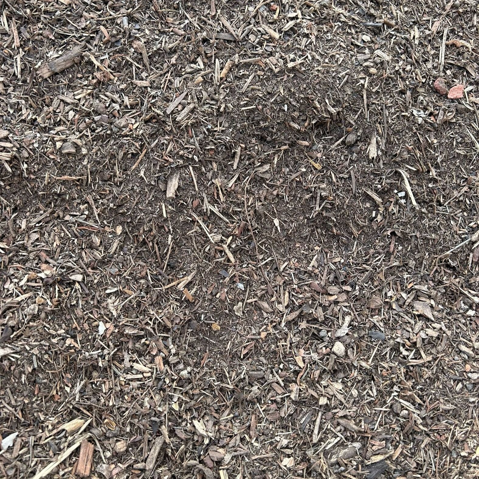 A pile of wood chips sitting on top of a pile of dirt.