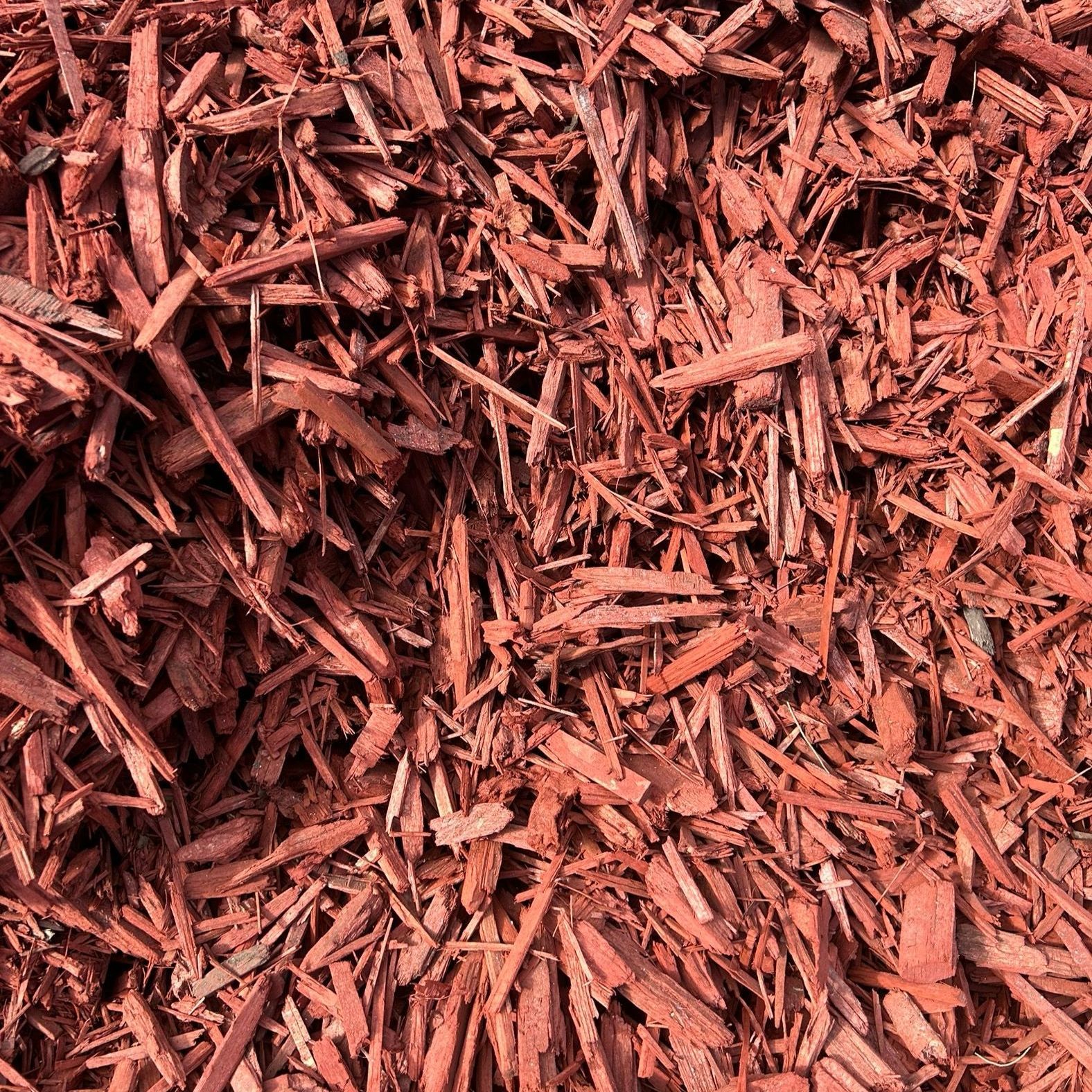 A pile of red mulch is sitting on the ground.
