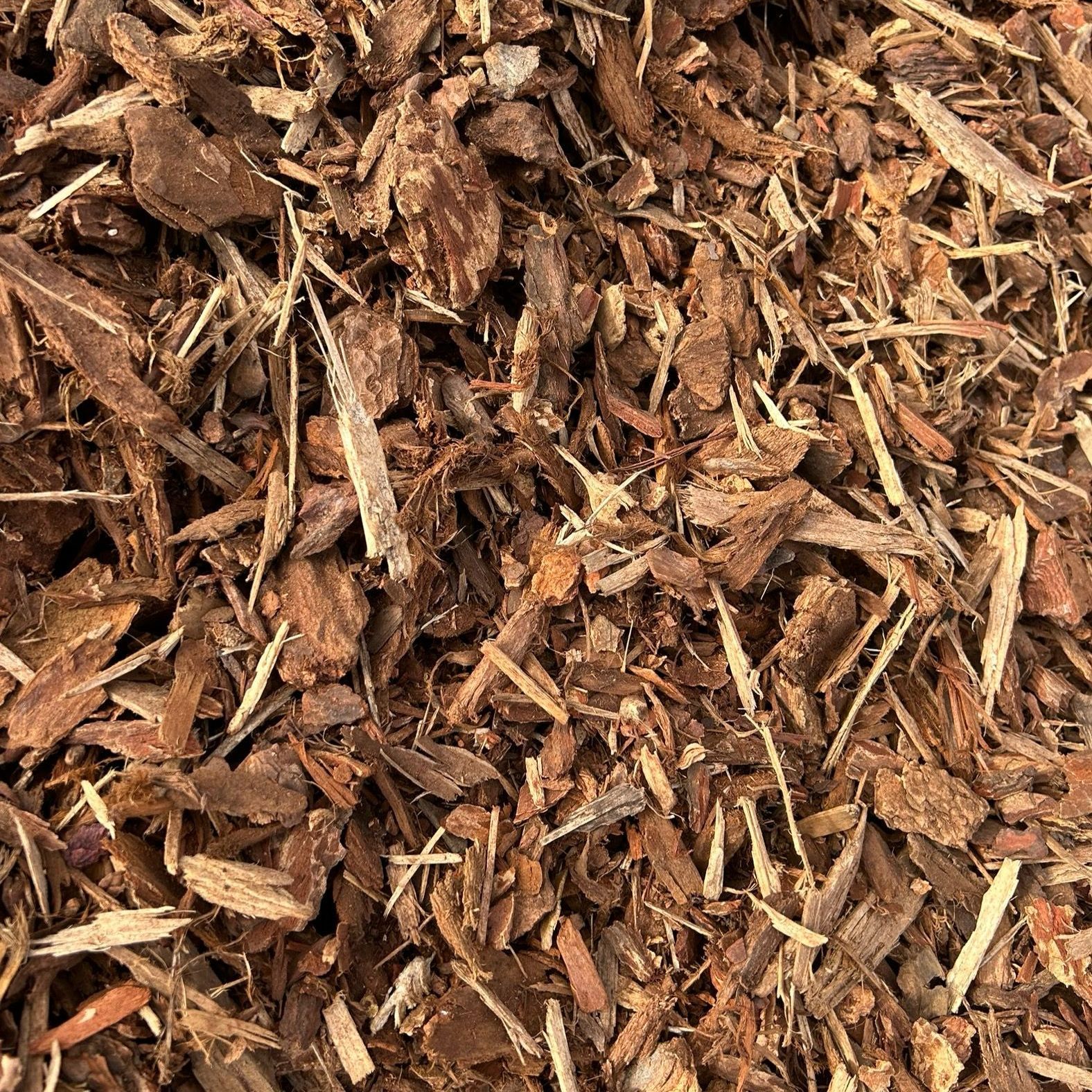 A pile of wood chips is sitting on the ground.