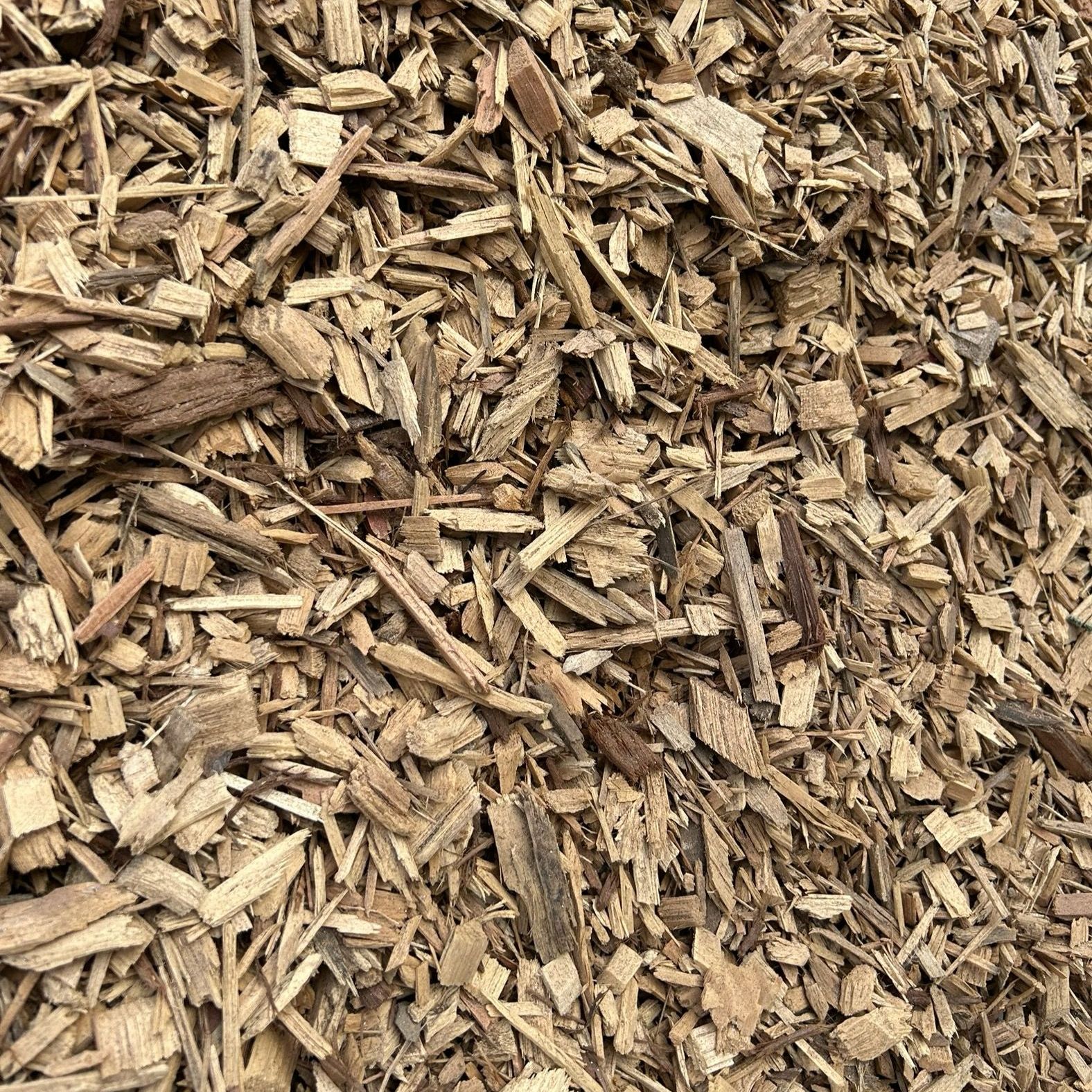 A pile of wood chips is sitting on the ground.