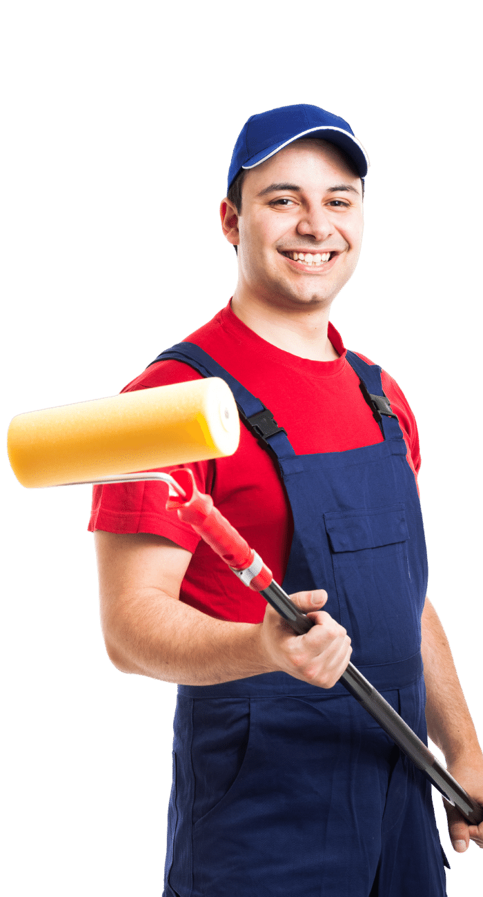 A man in overalls is holding a paint roller and smiling.