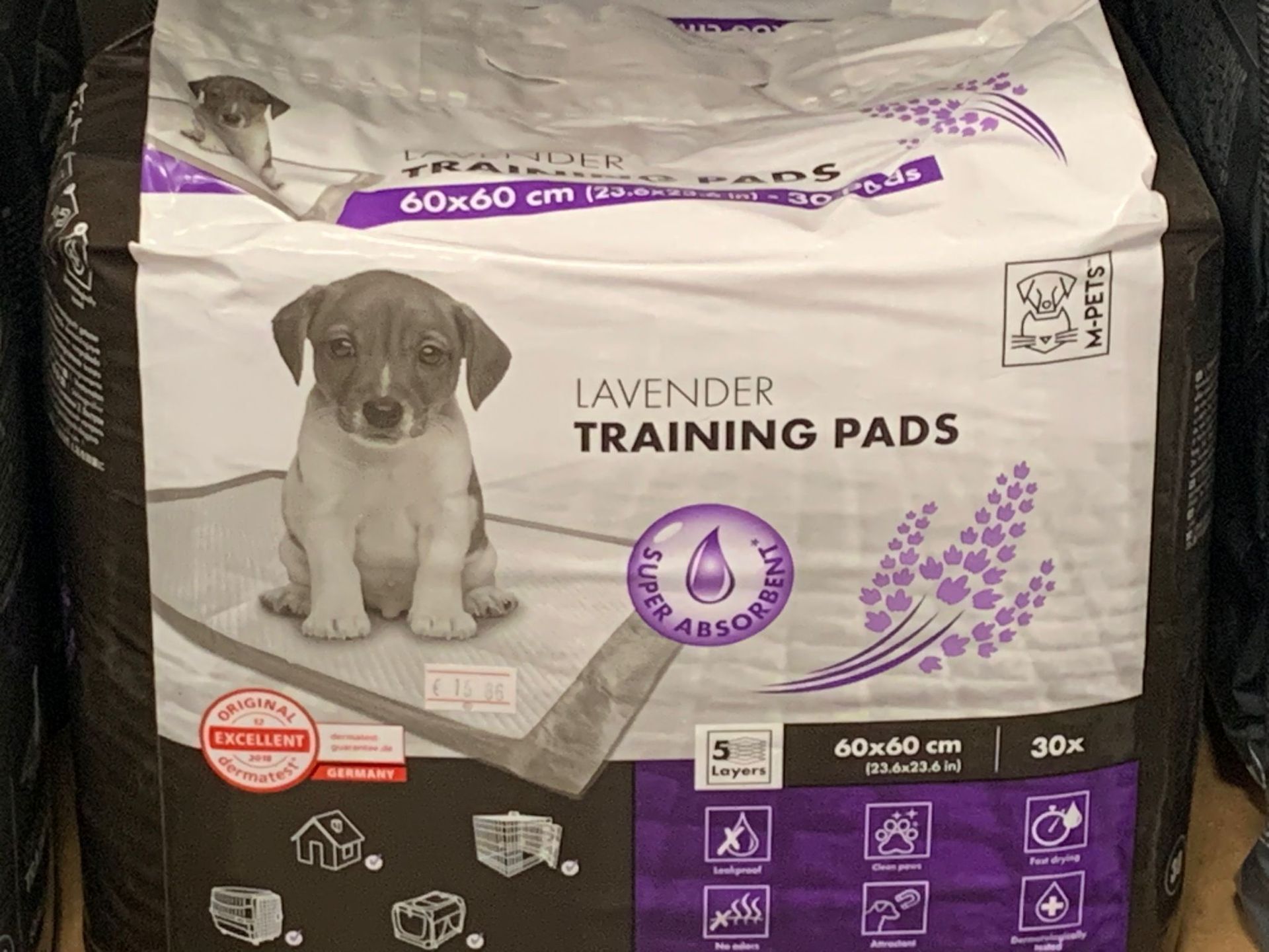 Una busta di tappetini da addestramento color lavanda con un cucciolo sopra