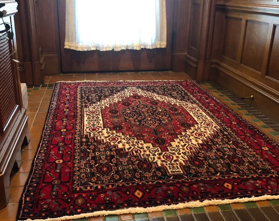 A rug is sitting on the floor in a room next to a window.