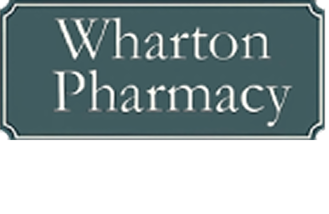 Wharton Pharmacy sign: white text on a teal rectangle with a decorative border.