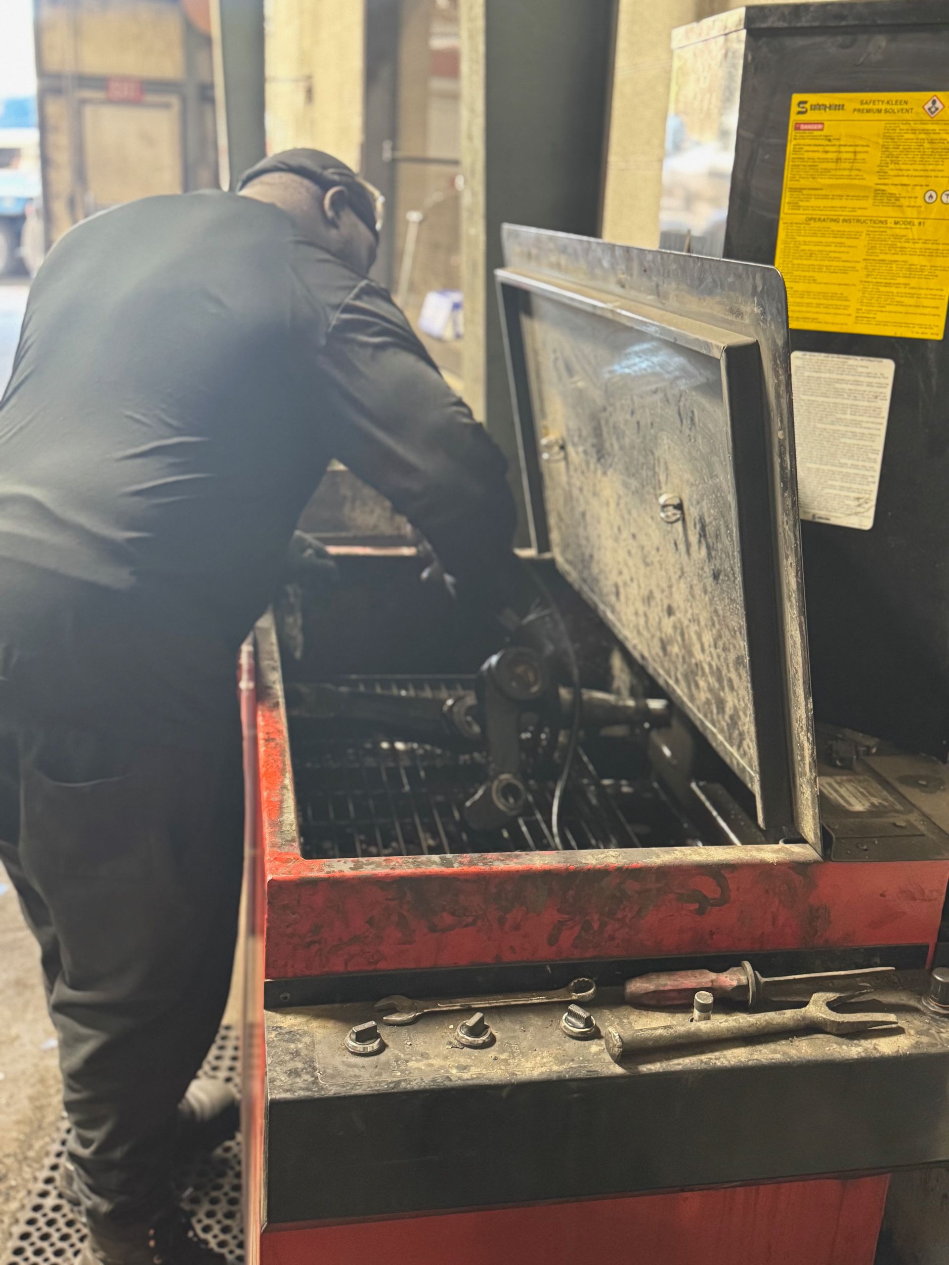 Hand in a work glove grips the steering wheel of a forklift.