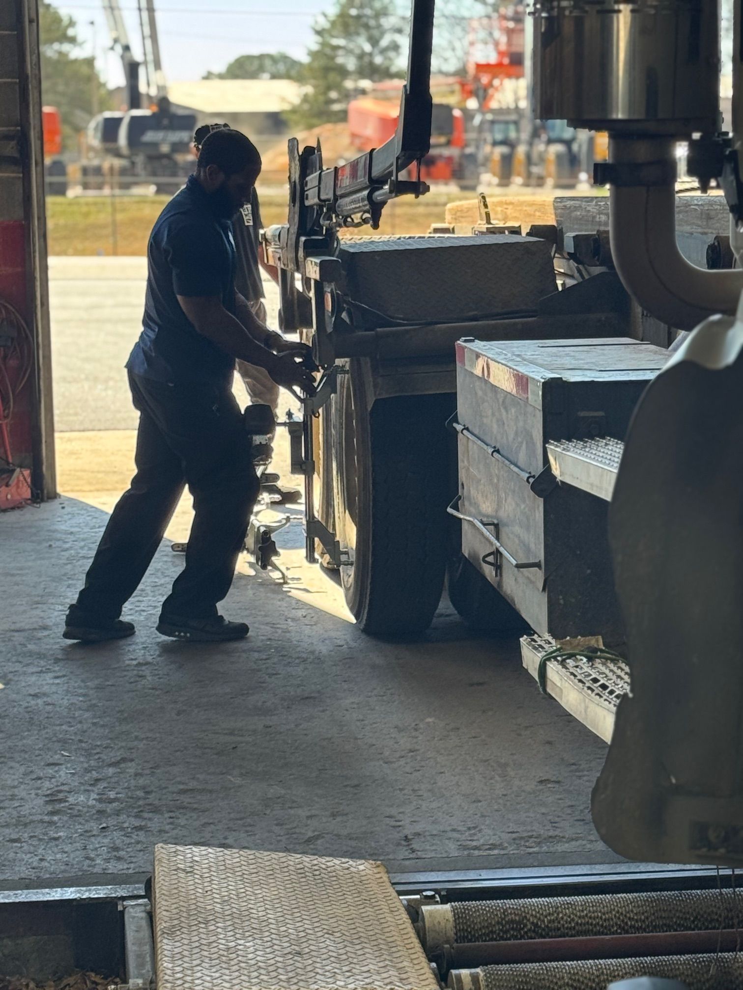 Undercarriage of a car on a lift; shock absorber, spring, and wheel visible.