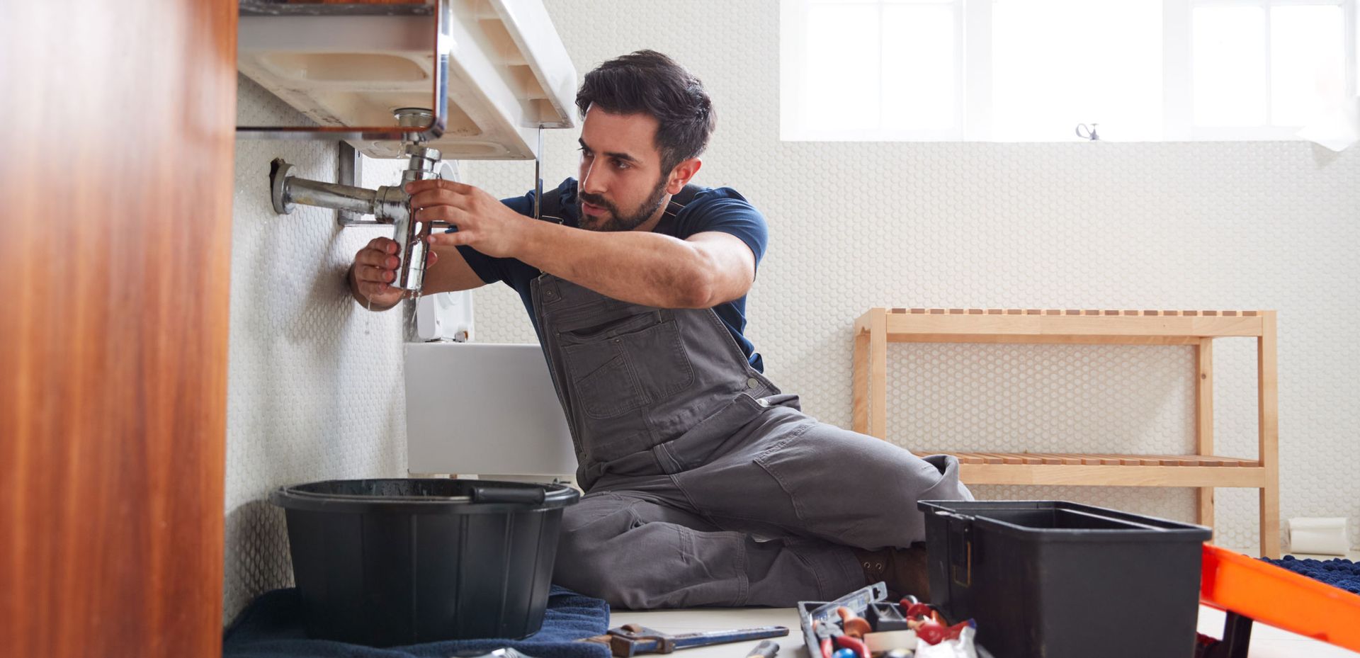 Worker Repairs Sink in the Bathroom — Santa Margarita, CA — RSM Plumbing