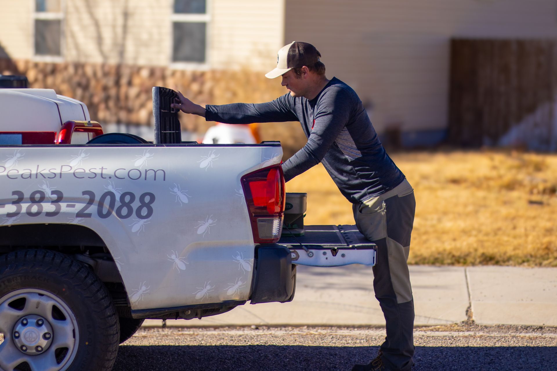 A Three Peaks Pest Control technician grabbing equipment to spray a home in Ivins Utah. 