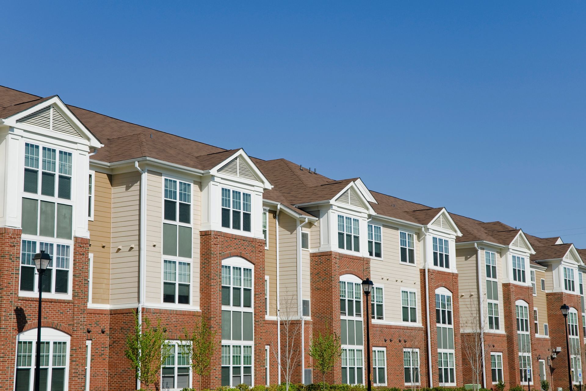 A large apartment building with a blue sky in the background