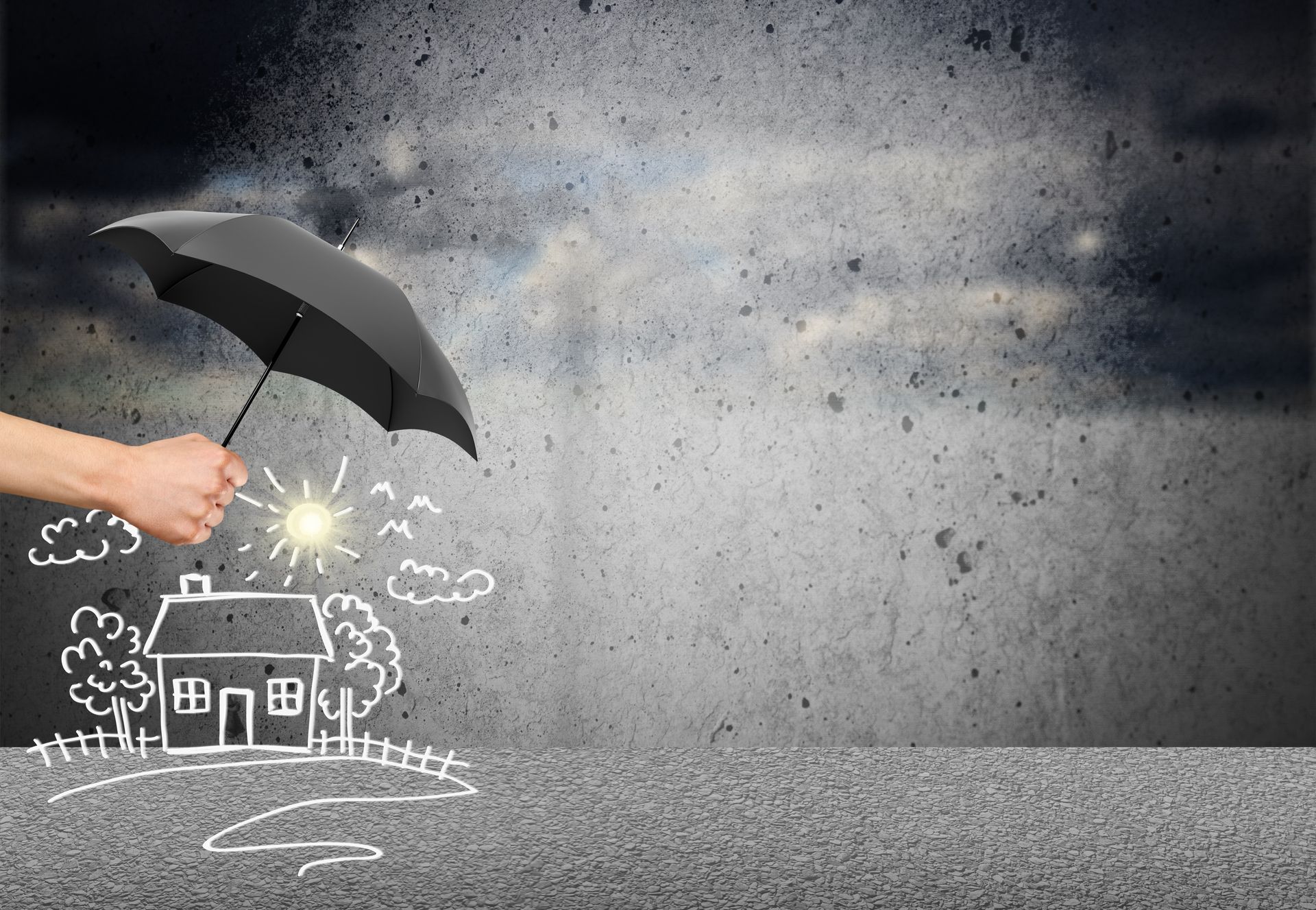A person is holding an umbrella over a drawing of a house