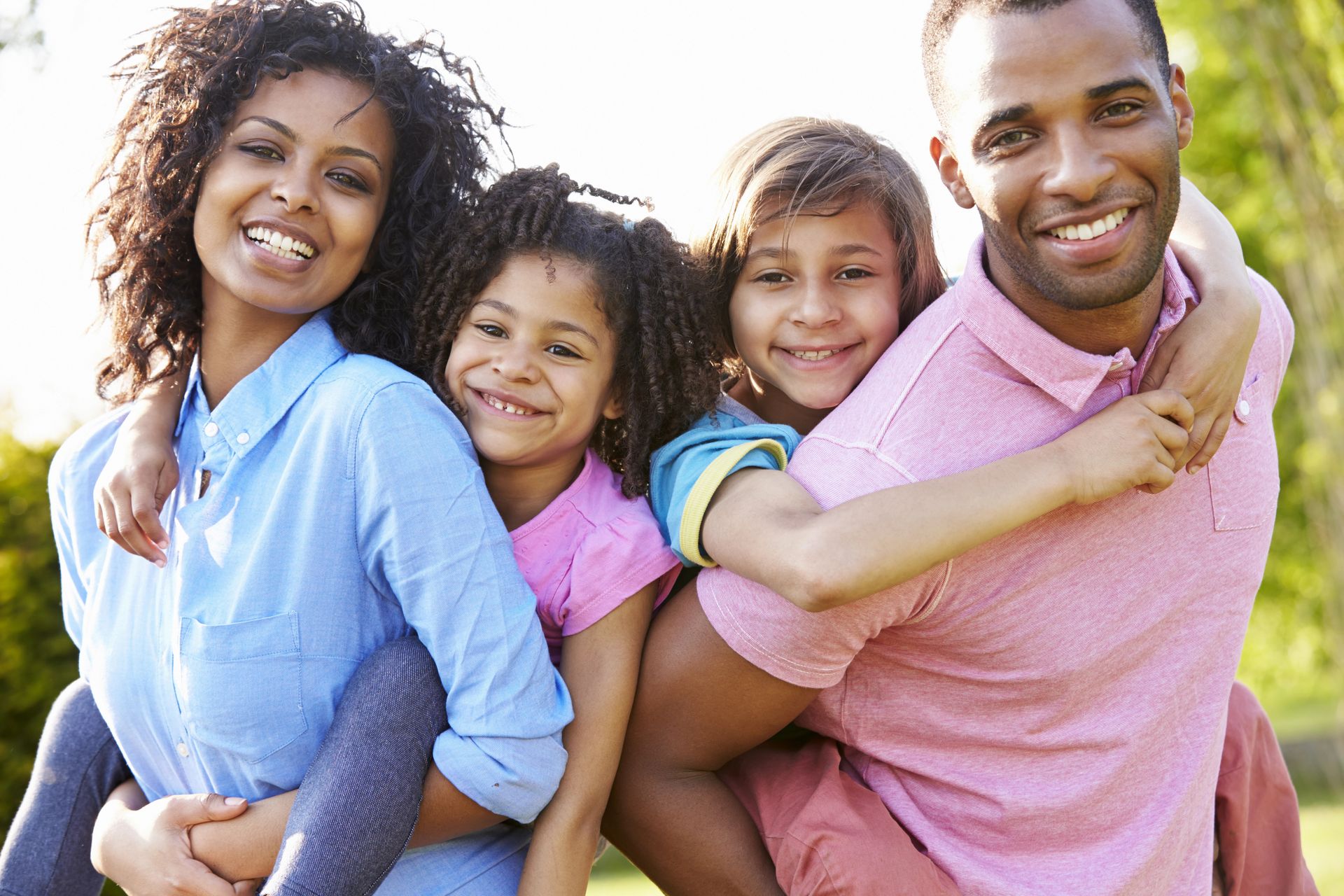 A family is posing for a picture together in a park.