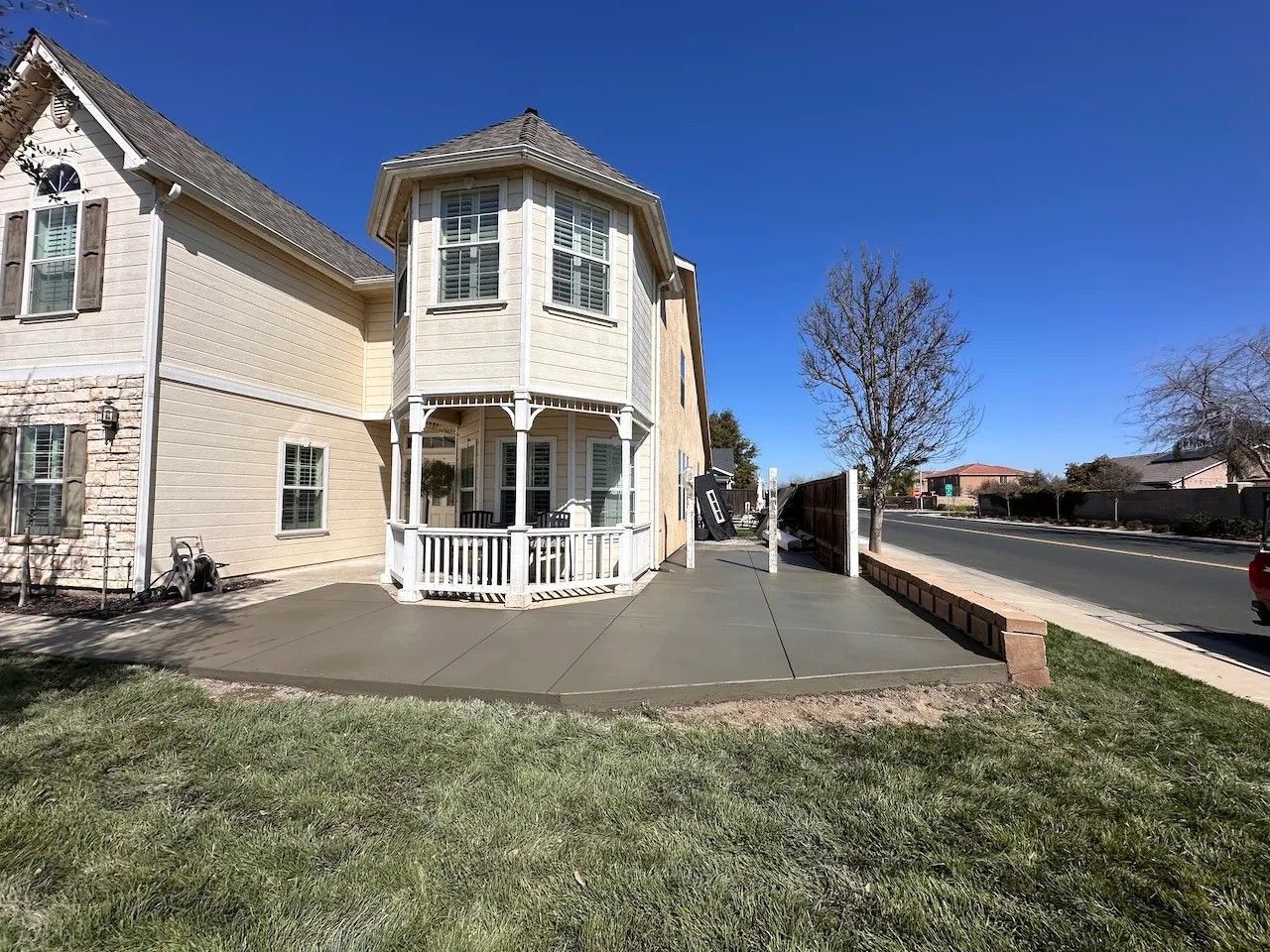 Victorian-style house with a bay window, small front yard, and sidewalk under a clear blue sky