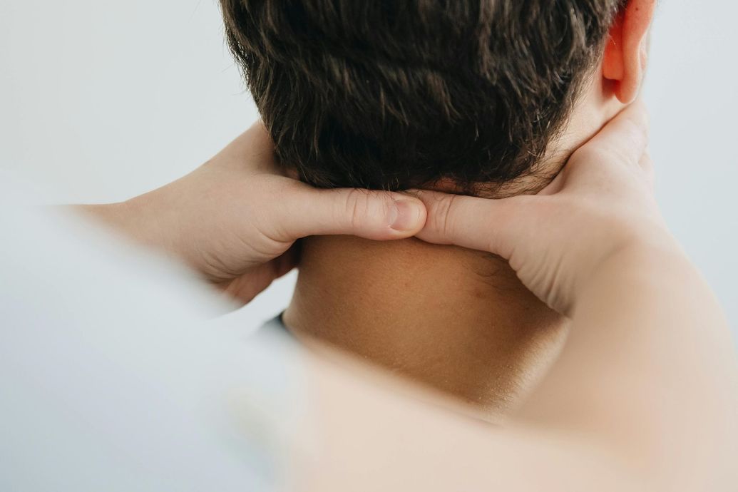 Hands gently massaging the back of a person's neck.