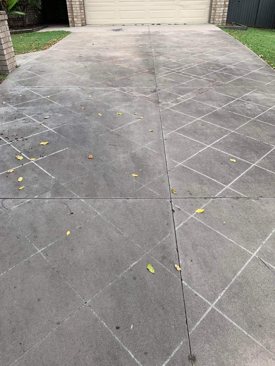 A Concrete Driveway With a Checkered Pattern and a Garage Door in the Background — Derek's Dirty Deeds In Booral, QLD
