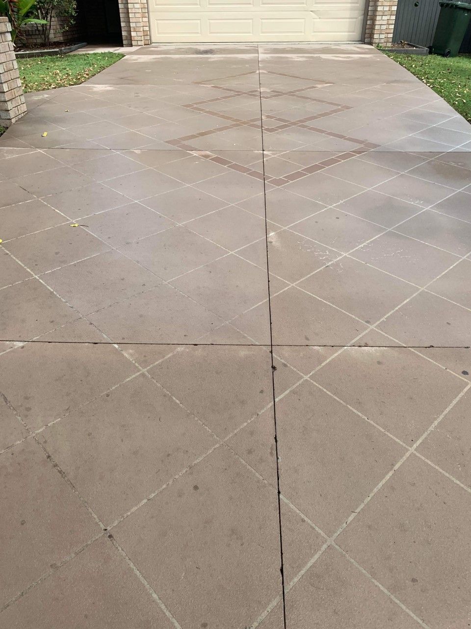 A Concrete Driveway With a White Garage Door in the Background — Derek's Dirty Deeds In Booral, QLD