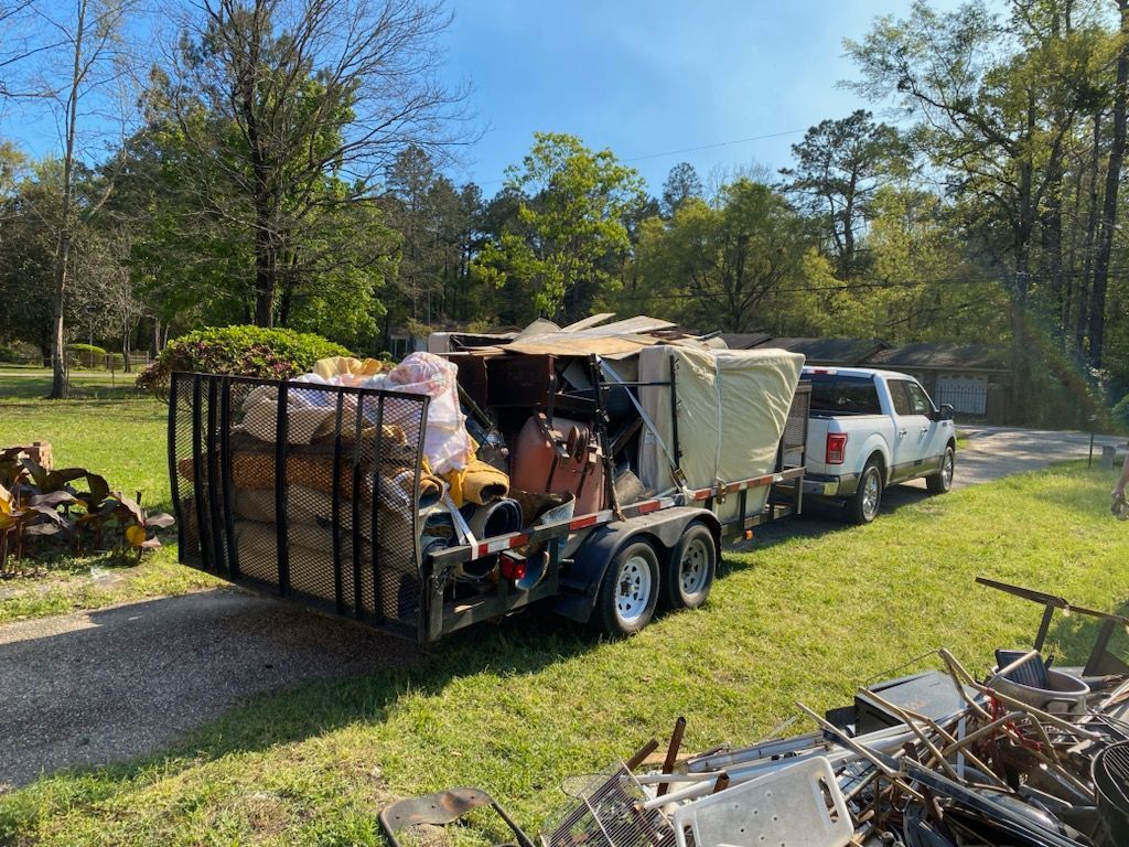A truck is pulling a trailer full of trash.