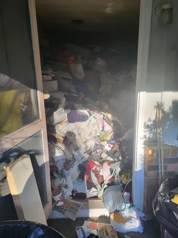 A messy room with a lot of trash on the floor.