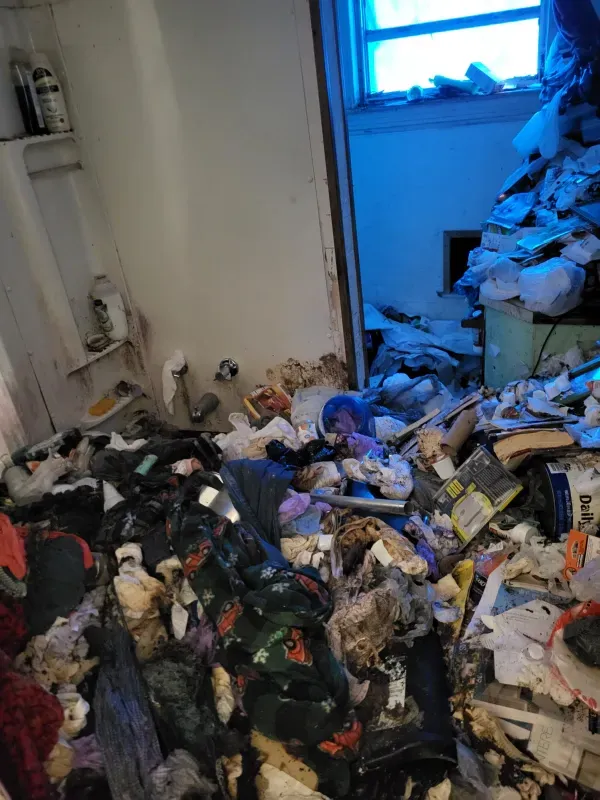 A bathroom filled with lots of trash and junk.