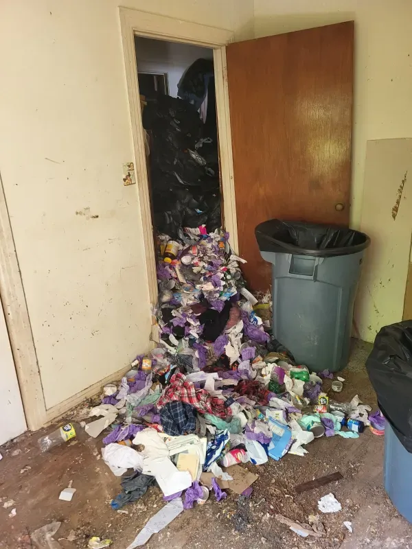 A room filled with trash and a trash can.