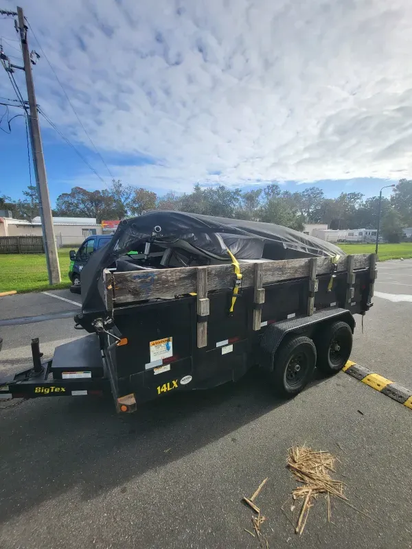 A dumpster trailer is parked on the side of the road.