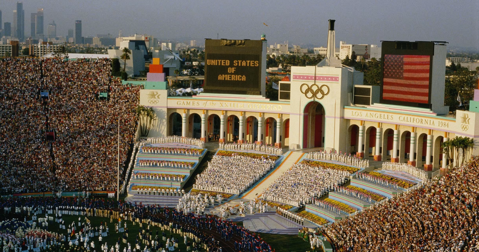Opening ceremony of the 1984 Los Angeles Olympics at the Coliseum; large crowds, the Olympic rings, and U.S. flag.