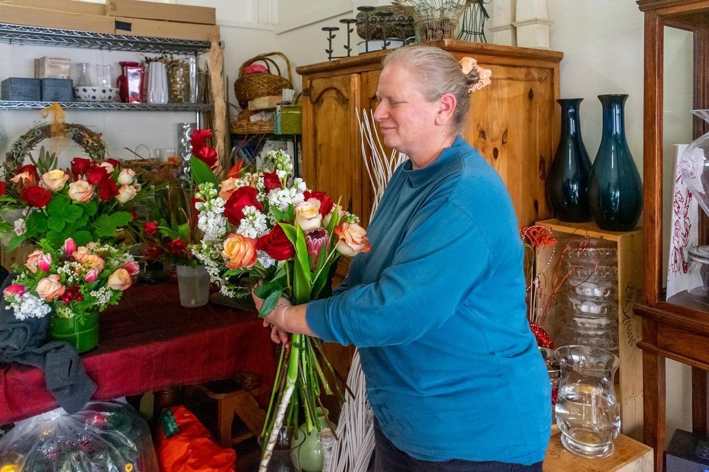 A woman is holding a large bouquet of flowers in a room.