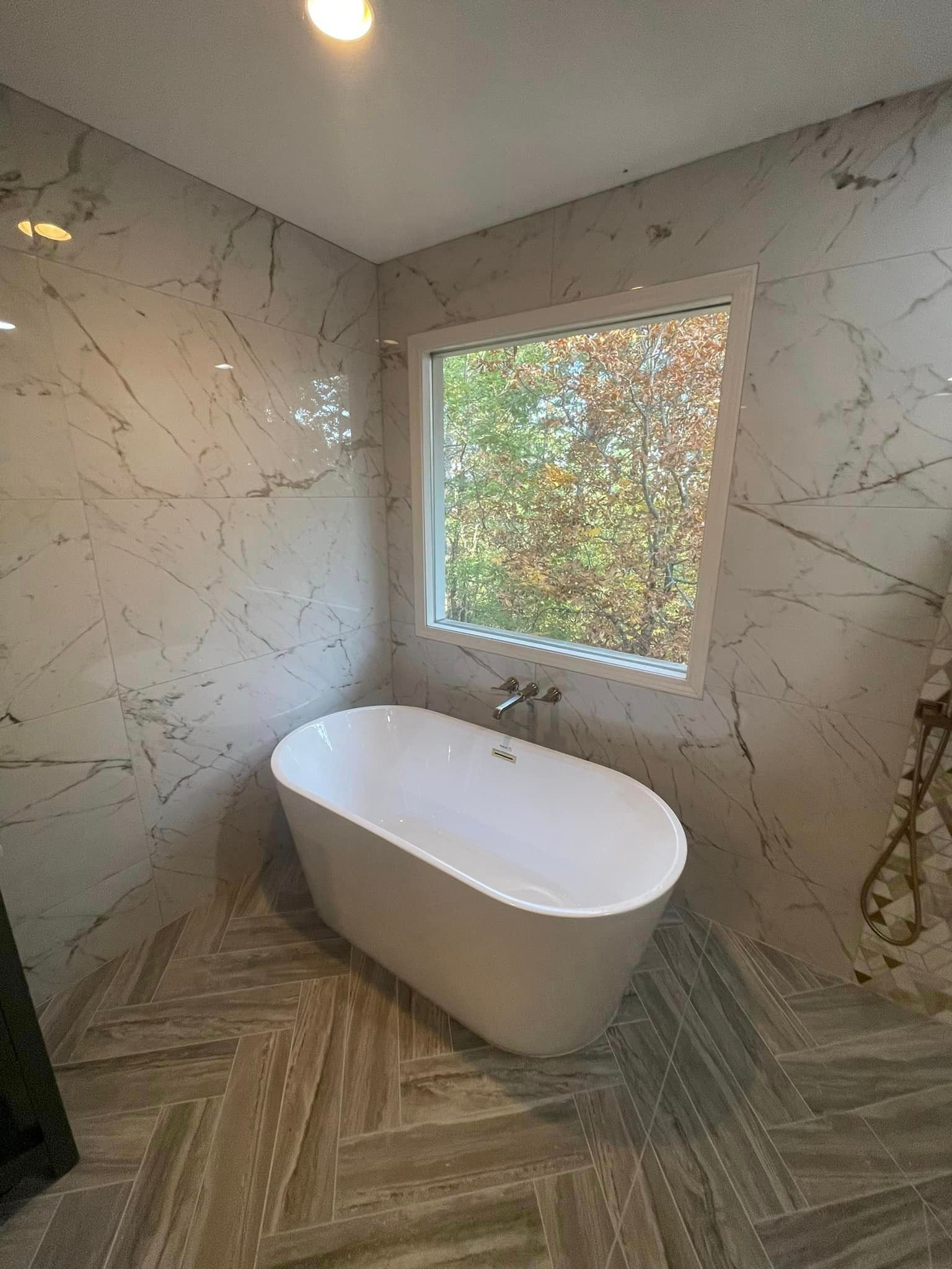 A bathtub is sitting in a bathroom next to a window.