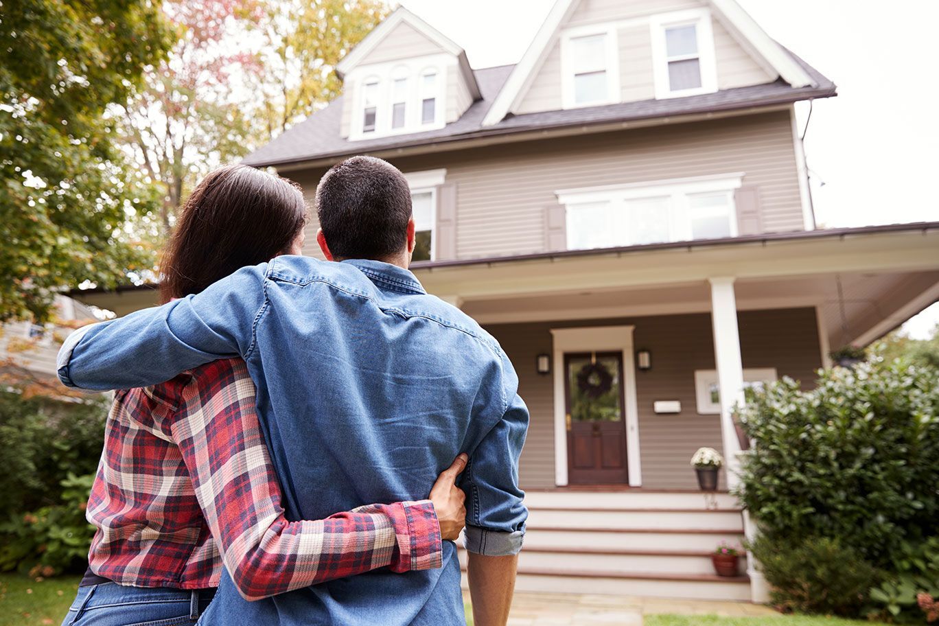 First time Northeast Ohio home buyers standing outside their Cleveland home that they just closed on with their mortgage lender