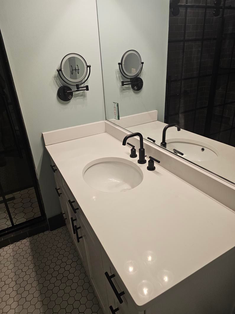 A bathroom with a sink and two mirrors on the wall.