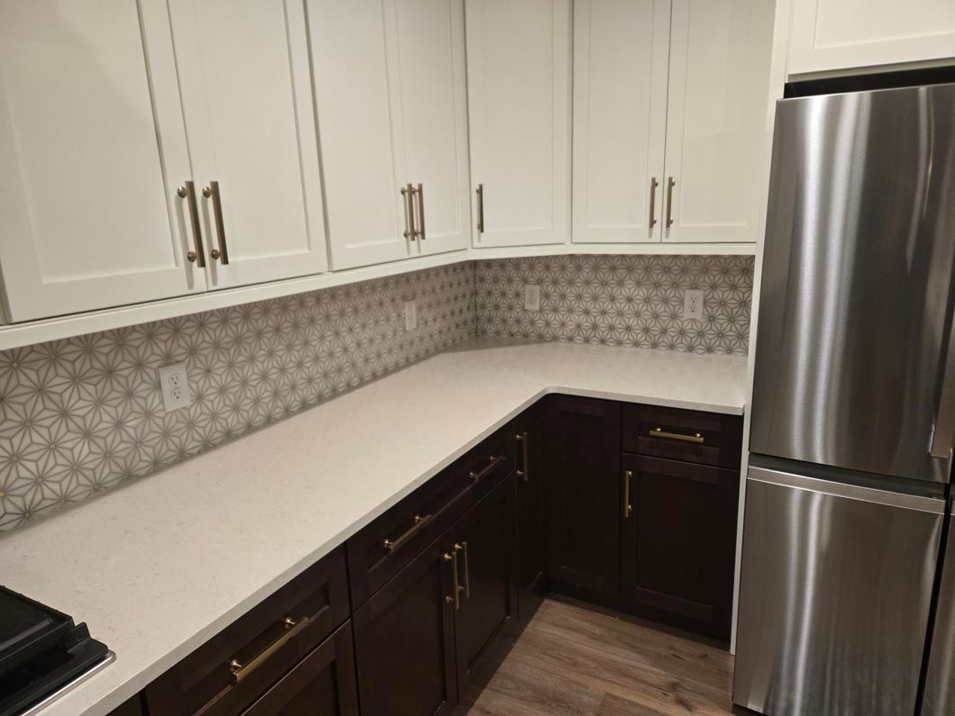 A kitchen with stainless steel appliances and white cabinets.
