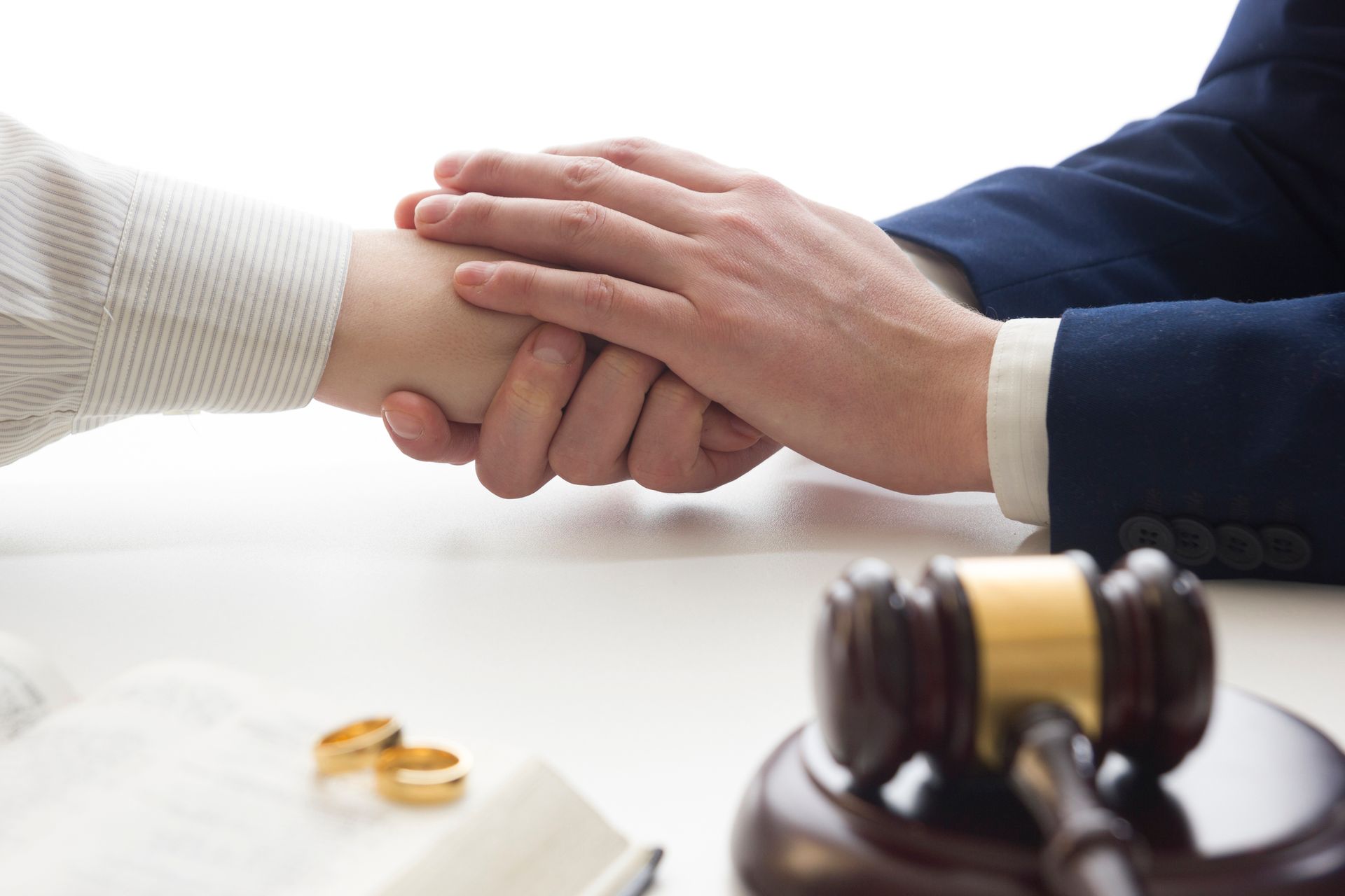 A man and a woman are shaking hands in front of a judge 's gavel.