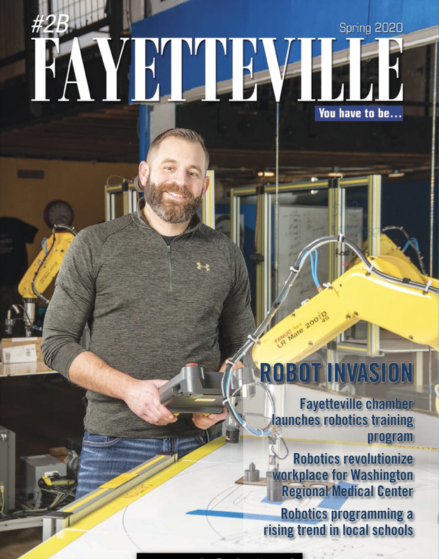 a man is holding a robot arm on the cover of a magazine .