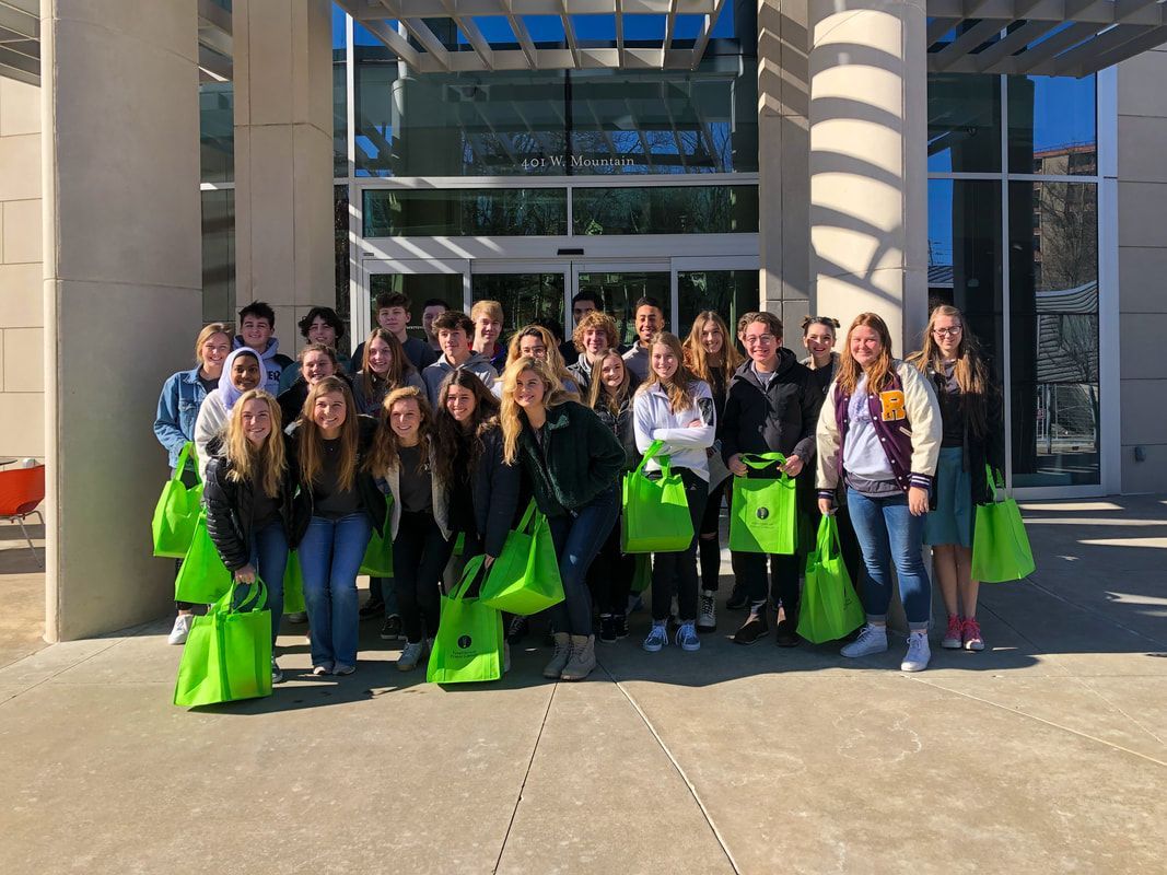 a group of people are posing for a picture in front of a building .