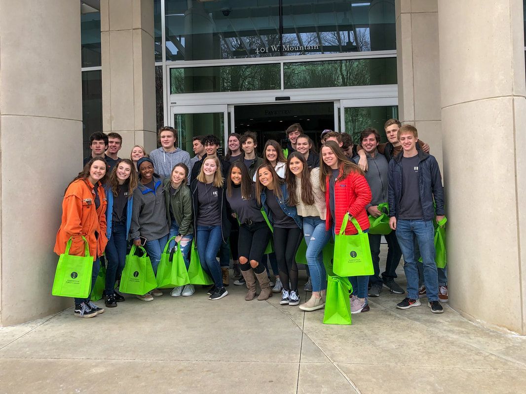 a group of people are posing for a picture in front of a building .