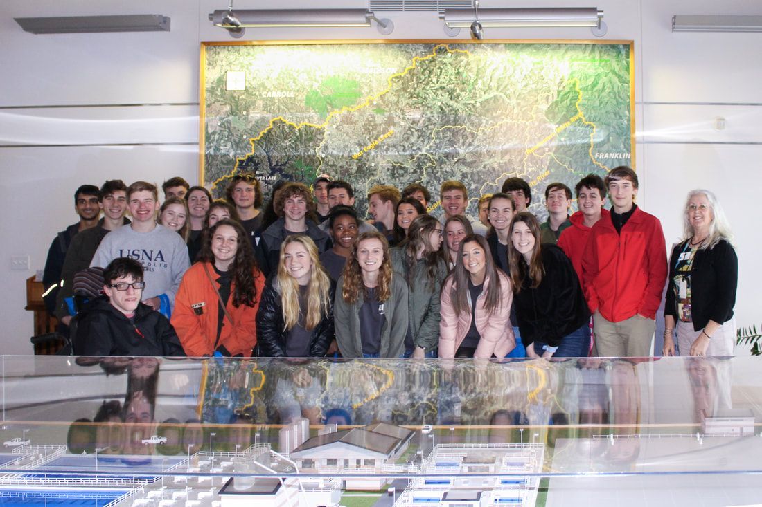 a group of young people are posing for a picture in front of a large map .