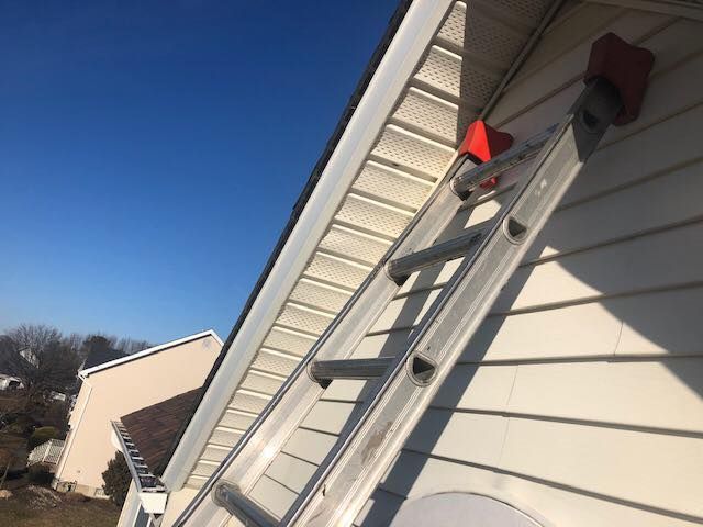White house exterior with windows, dark tiled roof.