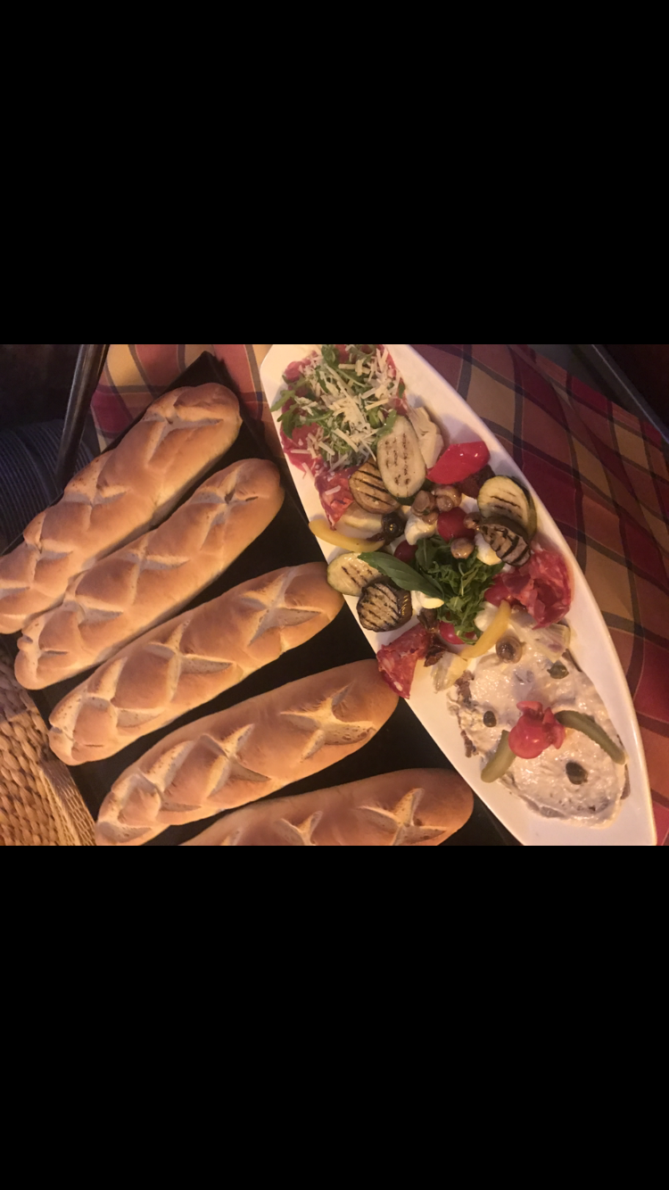 Ein Teller mit Essen, Brot und Gemüse auf einem Tisch.