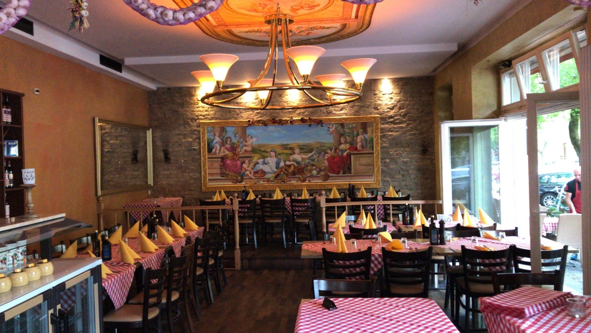 Ein Restaurant voller Tische und Stühle und einem Kronleuchter.