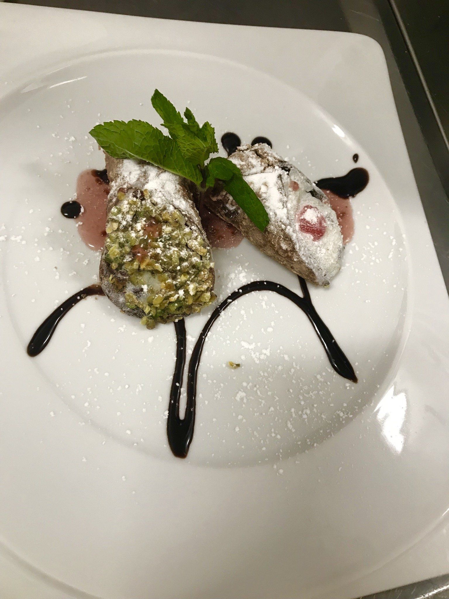 Ein weißer Teller mit einem Dessert und Minzblättern